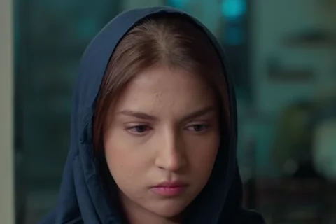 Dananeer Mobeen as Hurmat in a navy dupatta, looking down