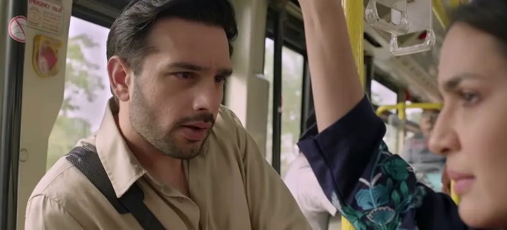 Usama Khan standing in a crowded bus beside a woman holding the overhead rail